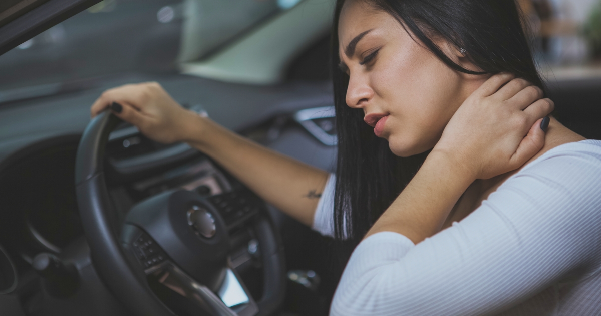 Female driver rubbing her aching neck after long d